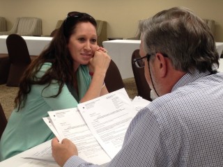 Gatlinburg wildfire survivor Melissa Starling receives advice from pro bono attorney David Draper of Knoxville, at a legal clinic in Sevierville, Tenn. on April 1, 2017